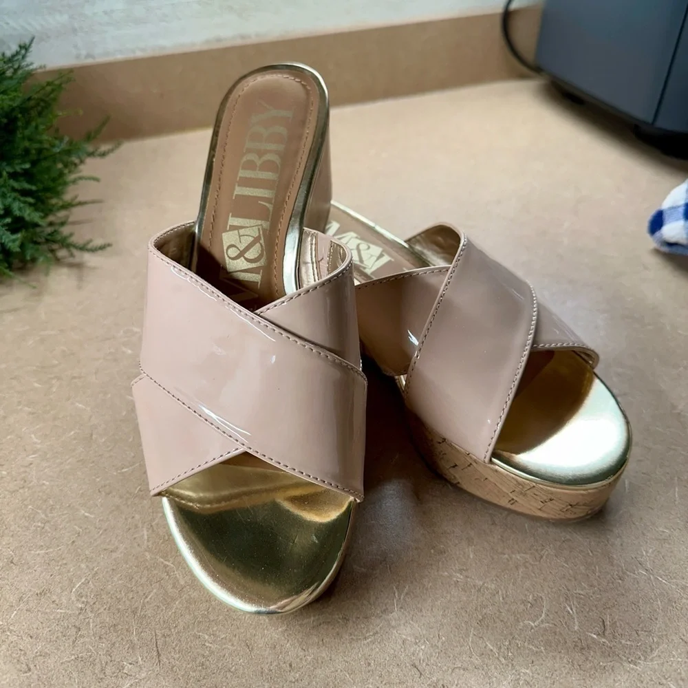 SAM&LIBBY, BEIGE PATENT,WEDGE SANDAL. CROSSOVER STRAPS ON A GOLDTRIMMED FOOTBED.